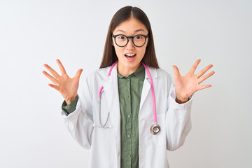 Young chinese dooctor woman wearing glasses stethoscope over isolated white background celebrating crazy and amazed for success with arms raised and open eyes screaming excited. Winner concept