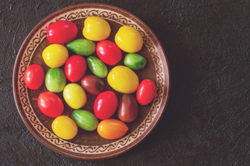 fresh colorful tomatoes. yellow, red, green tomatoes in a ceramic plate top view. flat lay. copy space.