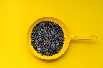 Colored pan in the hand. A hand is holding a yellow  pan on a colored background. Colored pan isolated. Cooking food concepts