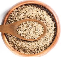 Cumin seeds (Cuminum), Jeera in a wooden cup and spoon on a white background
