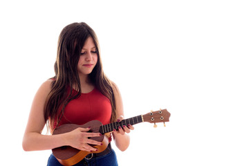 Fototapeta premium Teenage girl playing a ukelele, young artist with her musical instrument isolated