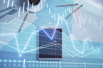 Double exposure of forex graph on digital tablet laying on table background. Concept of market analysis