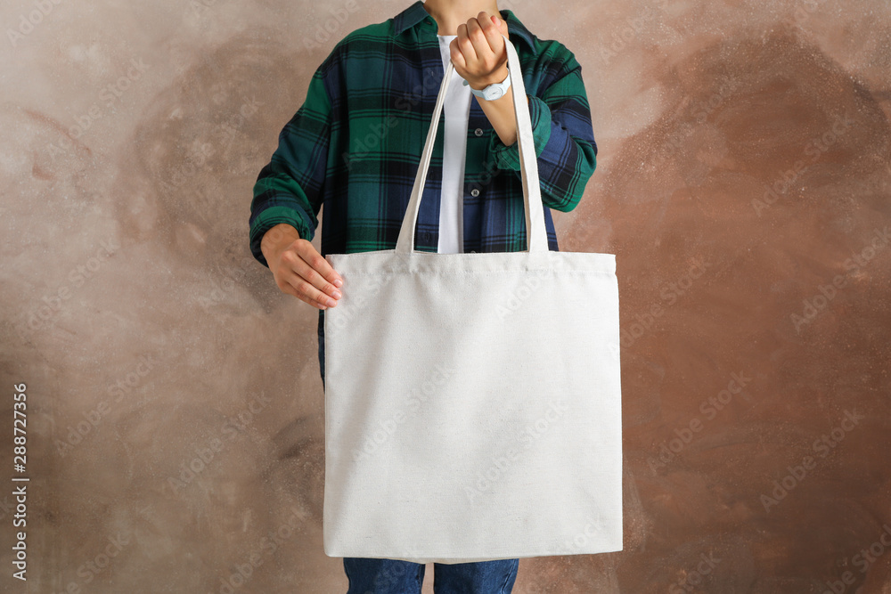 Sticker Young woman holding tote bag against brown background, empty space