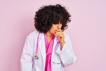 Young arab doctor woman with curly hair wearing stethoscope over isolated pink background feeling unwell and coughing as symptom for cold or bronchitis. Healthcare concept.