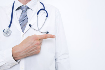 A doctor in a white coat points to copy space. 
