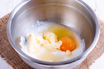 Mixing butter, sugar and eggs in bowl with mixing machine