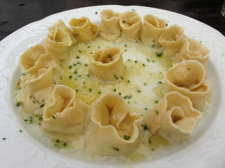 Herbs and ricotta stuffed Tortellini pasta in abundantly melted butter with chives and mountain cheese . Alto Adige, Italy