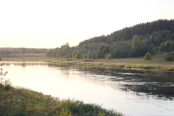 by the river in the countryside on a summer evening