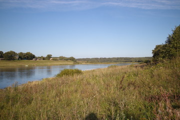 by the river in the countryside on a summer evening