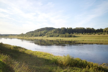 by the river in the countryside on a summer evening