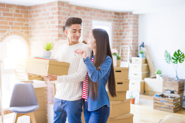 Young asian couple holding keys of new house, smiling happy and excited moving to a new apartment