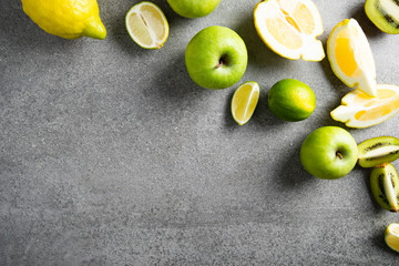 Fresh fruits on gray concrete background. Green and yellow healthy food, clean eating. Detox, dieting food.