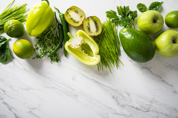 Fresh fruit, vegetable, greens on white marble background. Green healthy food, clean eating. Detox,...