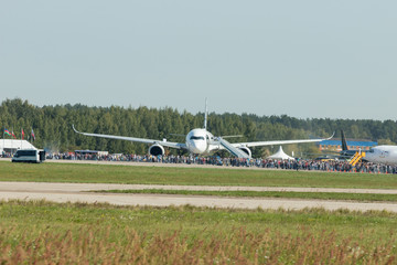 A passenger airplane on the outdoors exhibition of airplanes - people standing before it