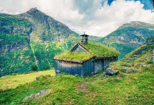 Norwegian typical grass roof wooden old house near Seven Sister waterfall. Colorful summer morning in Norway, Europe. Beauty of countryside concept background. Instagram filter toned.