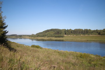 by the river in the countryside on a summer evening