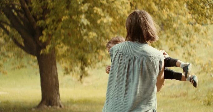 Mother and baby girl playing outside during the early fall season. Shot in 4K RAW on a cinema camera.