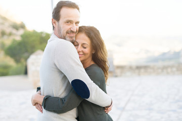 Obraz premium Romantic couple smiling, cuddling and hugging on a sunny day