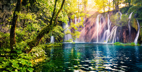 Last sunlight lights up the pure water waterfall on Plitvice National Park. Colorful spring panorama of green forest with blue lake. Great countryside view of Croatia, Europe. Orton Effect.