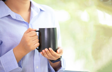 young woman holding black a glass