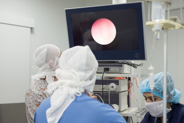 a team of doctors conduct an endoscopic examination of a child with a bladder disease. Cystoscopy.