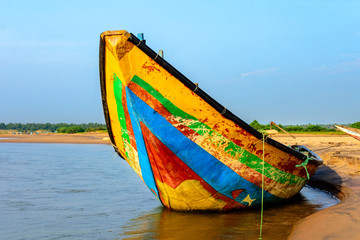 Traditional colorful fishing boat anchored at the confluence of Mahendra Tanaya river and Bay of...