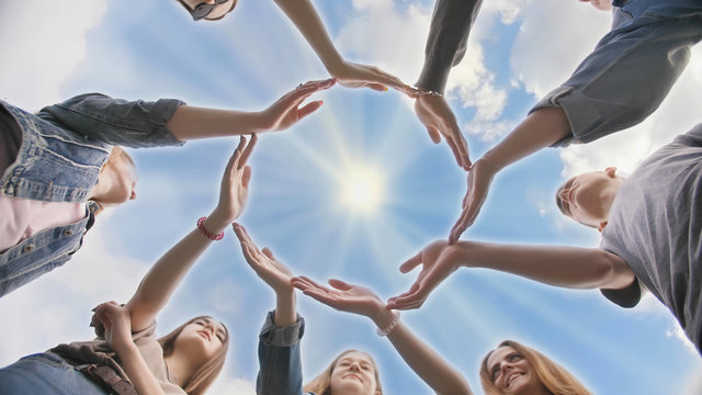 Conceptual symbol of cooperation diverse hands making a circle. Students help each other.