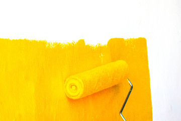Men painters are painting the walls with yellow.