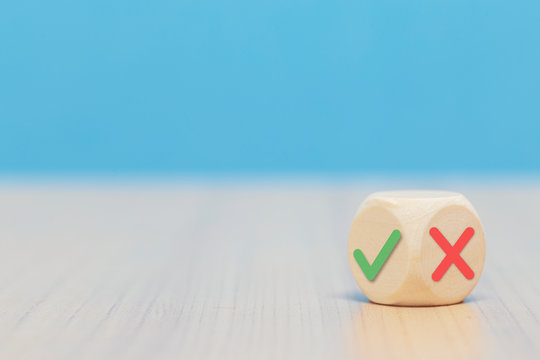 Yes or No symbols on wood blogs cube on blue background.