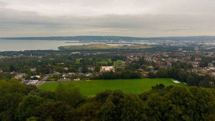 Fototapeta na wymiar Countryside, aerial view on houses near coast of Irish sea in Belfast Northern Ireland. Cloudy sky above seaside 