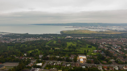 Countryside, aerial view on houses near coast of Irish sea in Belfast Northern Ireland. Cloudy sky above seaside 