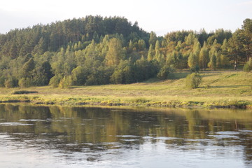 by the river in the countryside on a summer evening