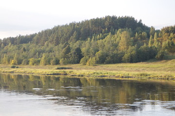 by the river in the countryside on a summer evening