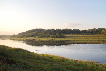 by the river in the countryside on a summer evening