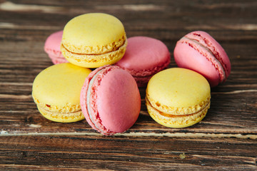 Sweet colorful French macaroon cookies dessert on brown wooden table