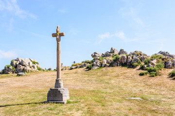 Eroded granite calvary of the chapel of Saint-Nicolas in Bugueles, Brittany, France, in front of a...
