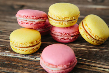 Sweet colorful French macaroon cookies dessert on brown wooden table over white wooden background