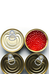 Red caviar of salmon fish. Four tinned metal cans. White background. Flat Lay. Copy space