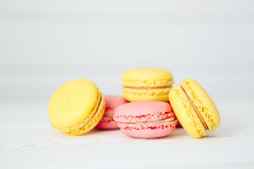 Sweet colorful French macaroon cookies dessert on white wooden table