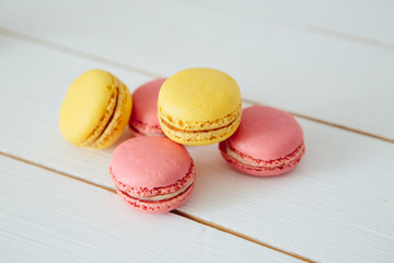 Sweet colorful French macaroon cookies dessert on white wooden table