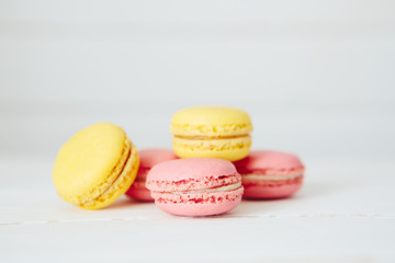 Sweet colorful French macaroon cookies dessert on white wooden table
