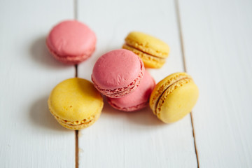 Sweet colorful French macaroon cookies dessert on white wooden table