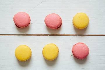 Obraz na płótnie Canvas Sweet colorful French macaroon cookies dessert on white wooden table