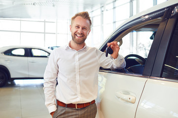 Happy buyer of a new car holds keys