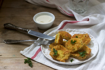 A traditional American dish of fried green tomatoes served with yogurt. Rustic style.