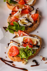 Bruschetta with tomatoes, lettuce, camambert, balsamic vinegar