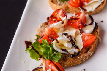 Bruschetta with tomatoes, lettuce, camambert, balsamic vinegar