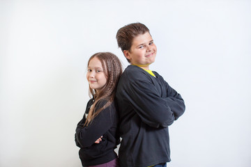 a little girl and a boy stand shoulder to shoulder