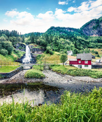 Fototapeta na wymiar Awesome summer scene of waterfall Steinsdalsfossen on the Fosselva River. Picturesque evenig scene of village of Steine, municipality of Kvam in Hordaland county, Norway. Orton Effect.