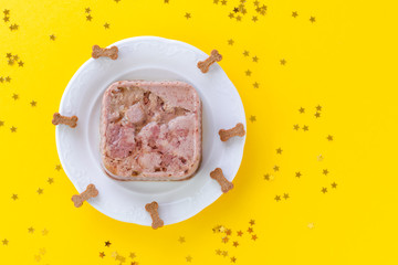 happy birthday cake for dog from wet food and treats on yellow with copy space